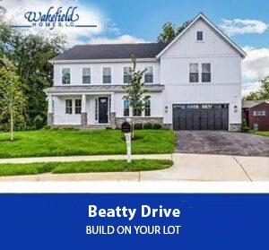 Front view of a white two-story house with a covered porch, green lawn, and a two-car garage on Beatty Drive (Wakefield Homes).