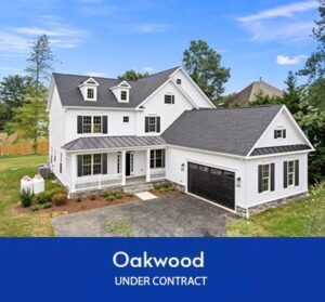 White two-story Oakwood home with a dark roof, front porch and attached two-car garage under contract.